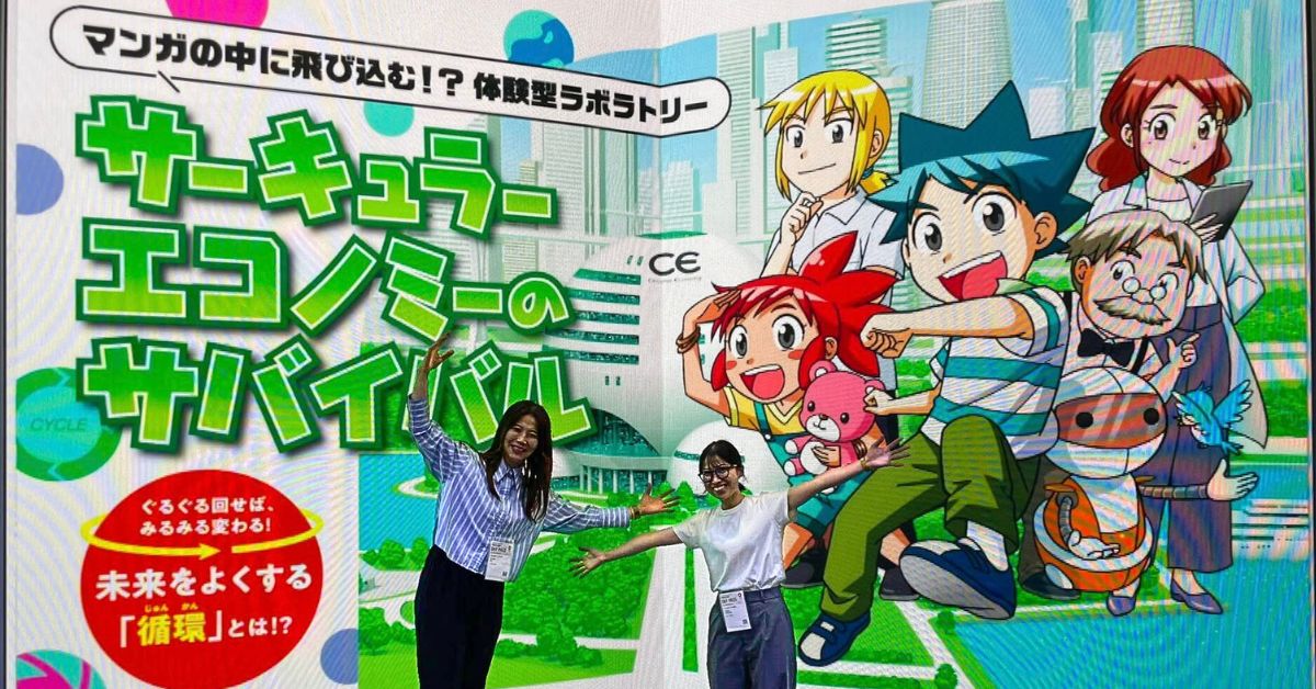 会場大型パネル前でポーズをする文と山口