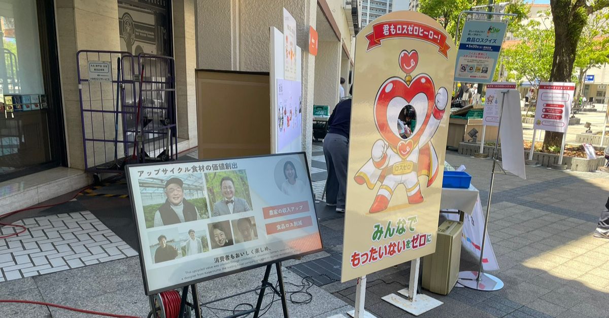 活動を伝える映像とロスゼロヒーローの顔出し看板